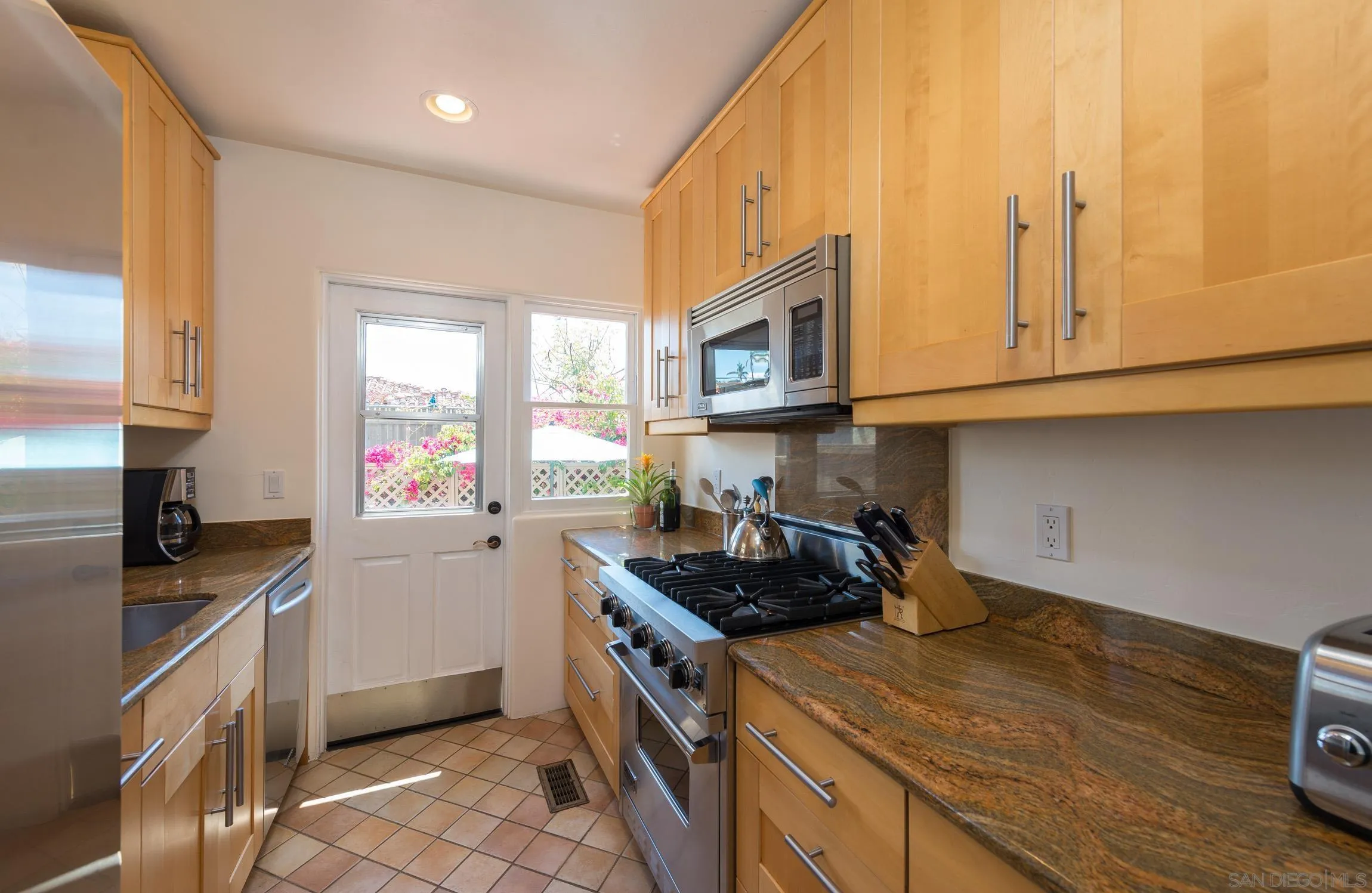 605 Arenas Street La Jolla, CA 92037 - Photo 10 of 25 a kitchen with stainless steel appliances granite countertop a sink stove and cabinets