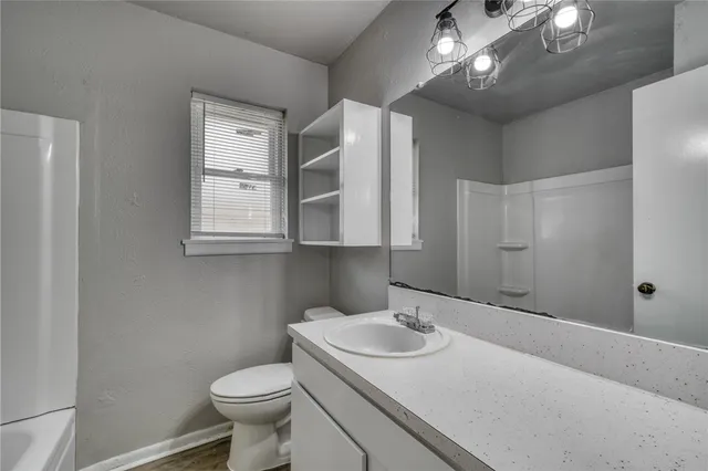 a bathroom with a sink toilet and window
