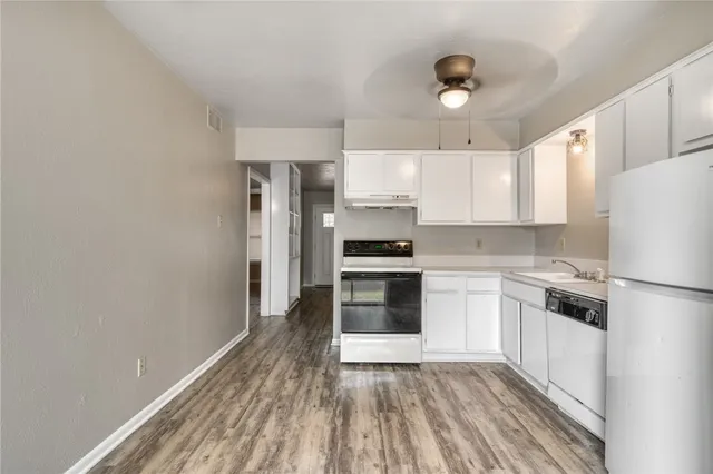 a kitchen with white cabinets and stainless steel appliances