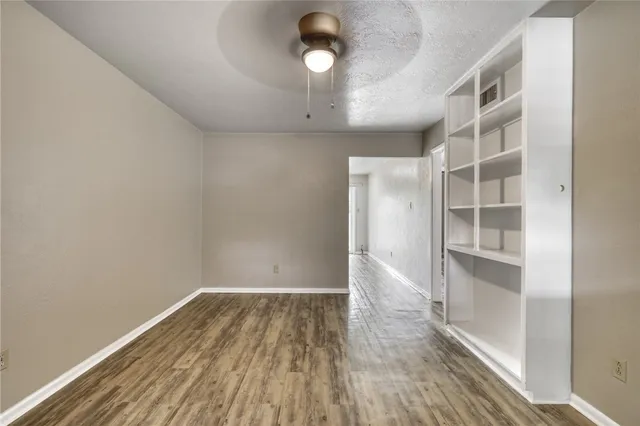 a view of a room with wooden floor and ceiling fan