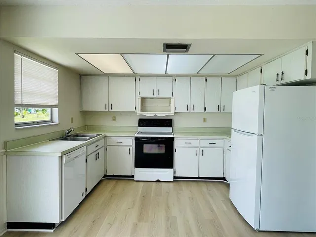 a kitchen with a stove a refrigerator and a sink