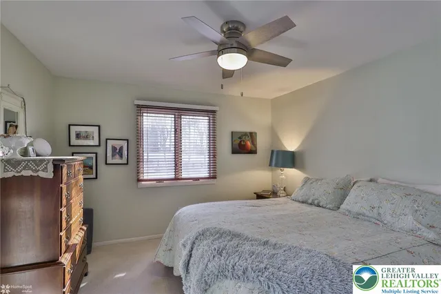 a view of a livingroom with a chandelier fan and windows