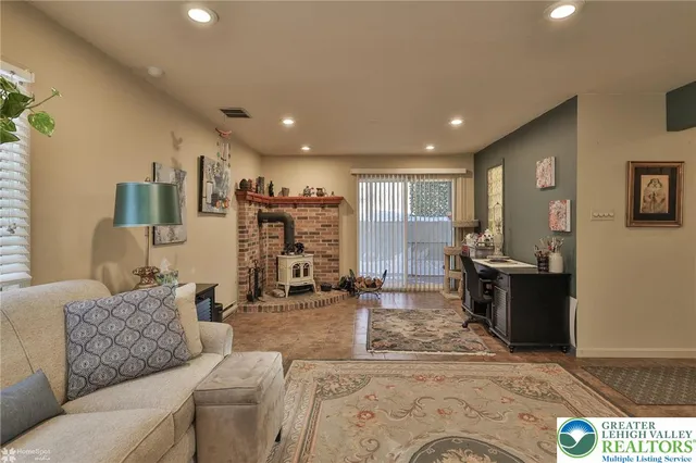 a living room with furniture a flat screen tv and large window