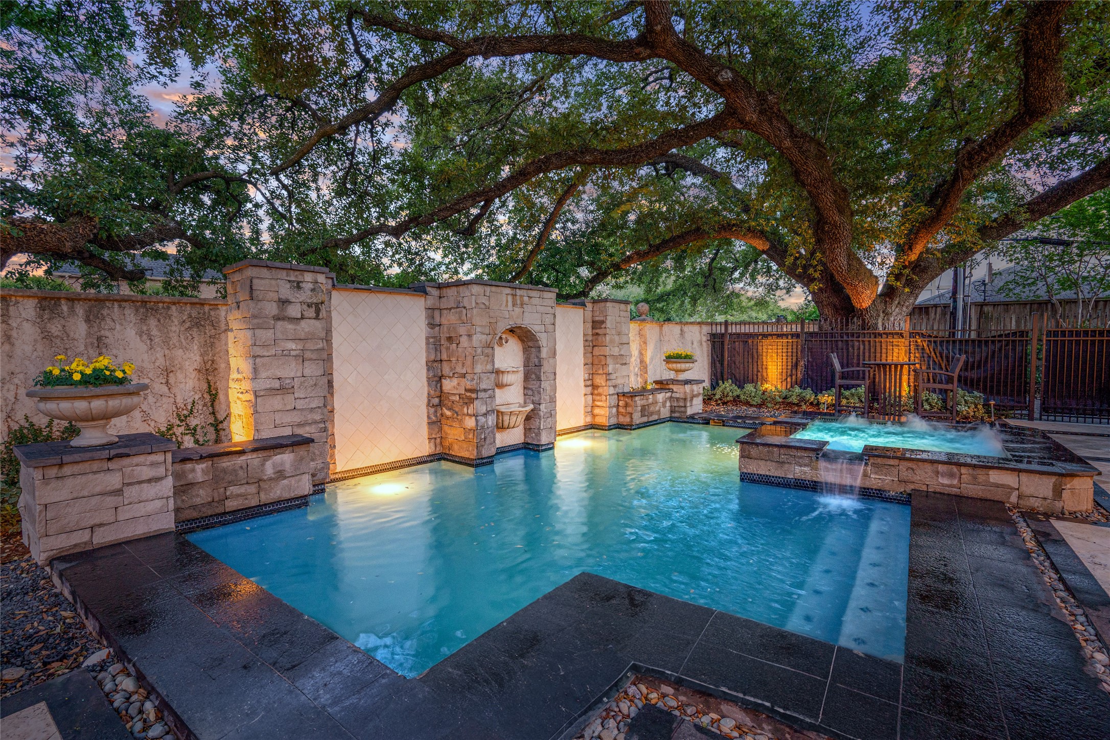 2105 Del Monte Drive Houston, TX 77019 - Photo 31 of 38 View of the amazing pool/spa and patio. Beautiful mature oak tree canopies! Fabulous fountains cascade down both tiled walls flanking the center lion's head fountain. A truly amazing pool with plenty of areas to unwind.