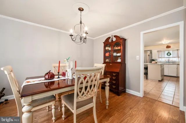 a dining room with furniture a chandelier and wooden floor