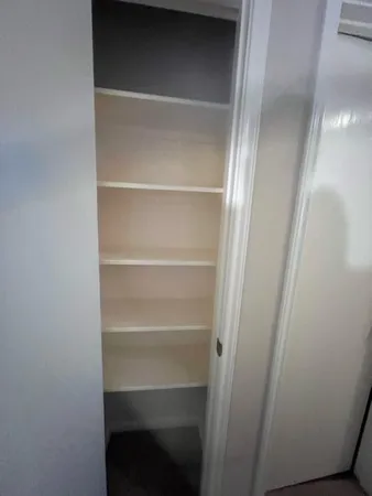a view of walk in closet with empty racks