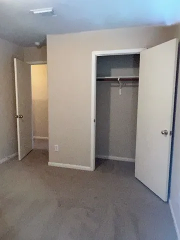 an empty room with closet and a fireplace