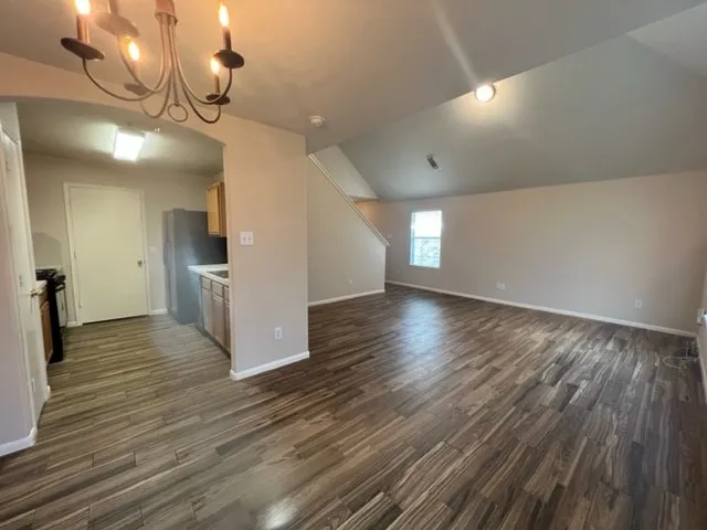 a view of empty room with wooden floor