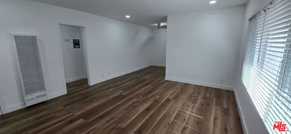 a view of a room with wooden floor and window