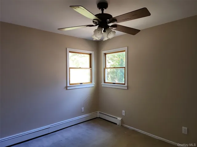 an empty room with a window and a fan