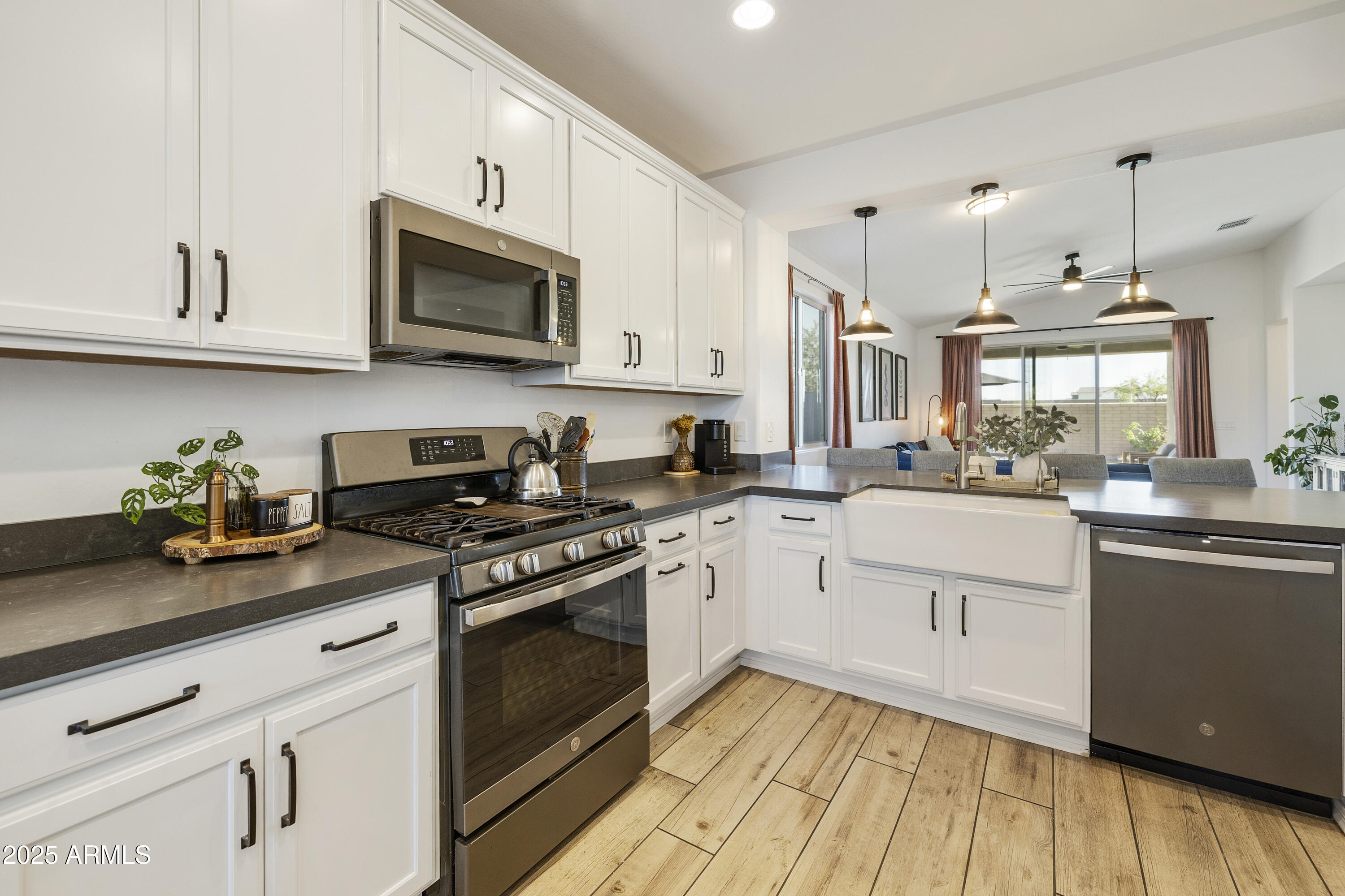 5813 South Del Rancho Mesa, AZ 85212 - Photo 5 of 47 a kitchen with stainless steel appliances granite countertop a stove a sink dishwasher and a microwave oven with wooden floor