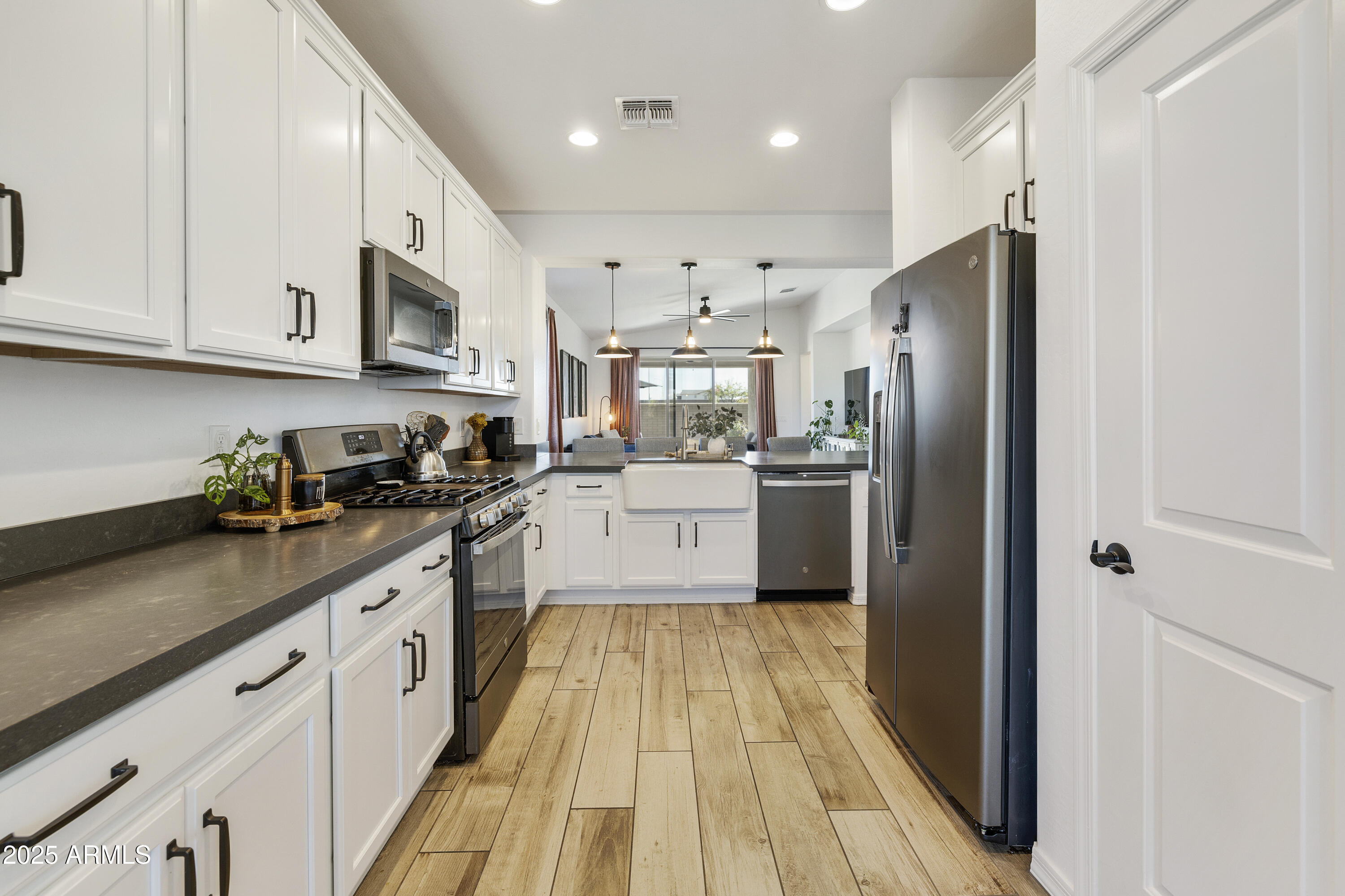 5813 South Del Rancho Mesa, AZ 85212 - Photo 6 of 47 a kitchen with stainless steel appliances granite countertop a refrigerator a sink dishwasher a oven with white cabinets and wooden floor