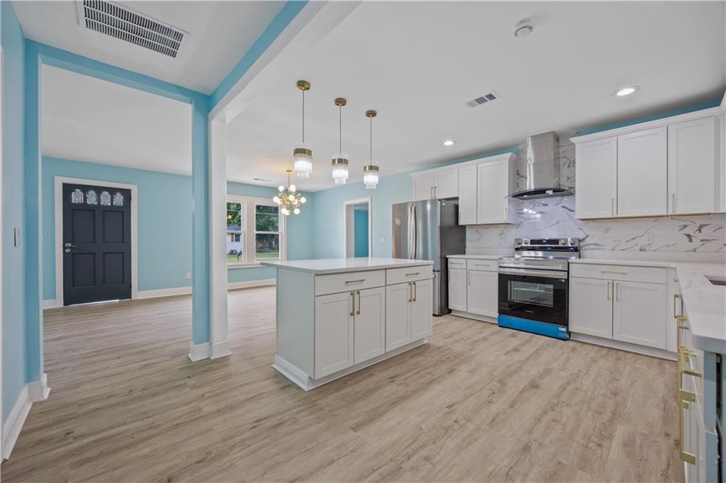 1658 Temple Avenue Atlanta, GA 30337 - Photo 11 of 27 a kitchen with granite countertop white cabinets and stainless steel appliances