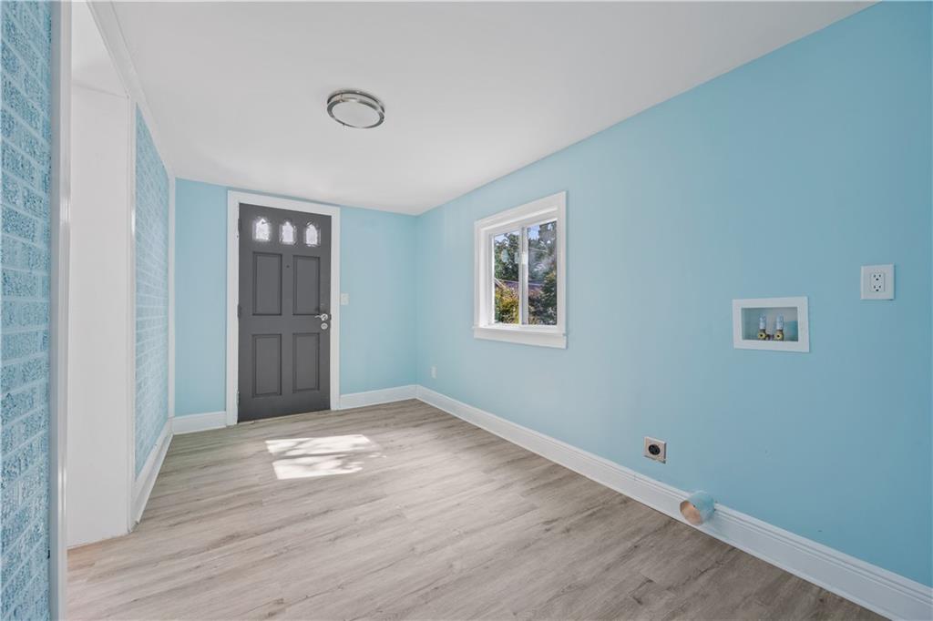 1658 Temple Avenue Atlanta, GA 30337 - Photo 13 of 27 an empty room with wooden floor and windows