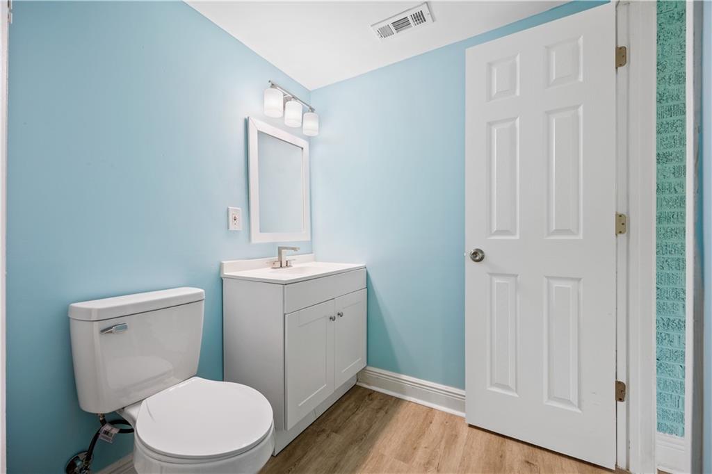 1658 Temple Avenue Atlanta, GA 30337 - Photo 15 of 27 a bathroom with a toilet a sink a vanity and mirror