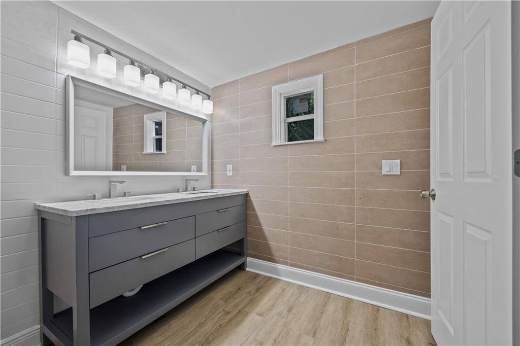 1658 Temple Avenue Atlanta, GA 30337 - Photo 20 of 27 a bathroom with a double vanity sink a mirror and a shower