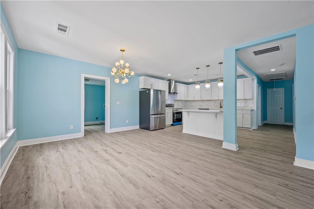 1658 Temple Avenue Atlanta, GA 30337 - Photo 3 of 27 a view of a kitchen with wooden floor and a refrigerator