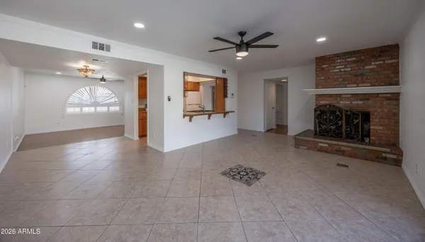 an empty room with windows and fireplace