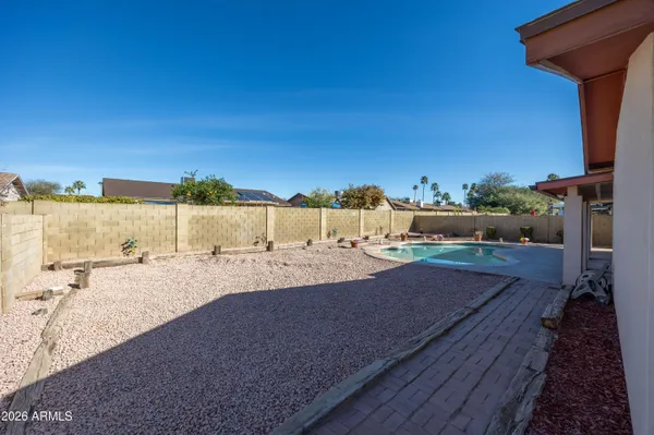 a view of a dry yard with wooden fence