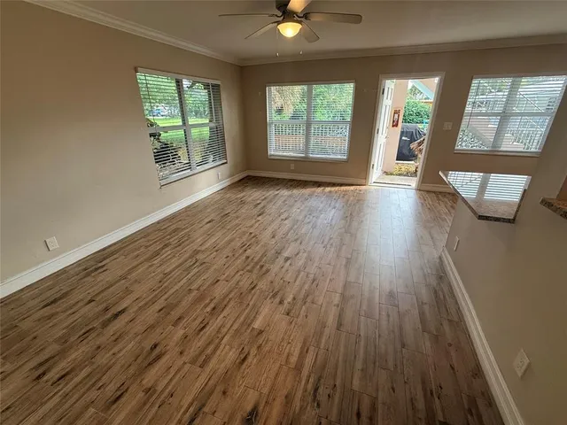 an empty room with wooden floor and windows