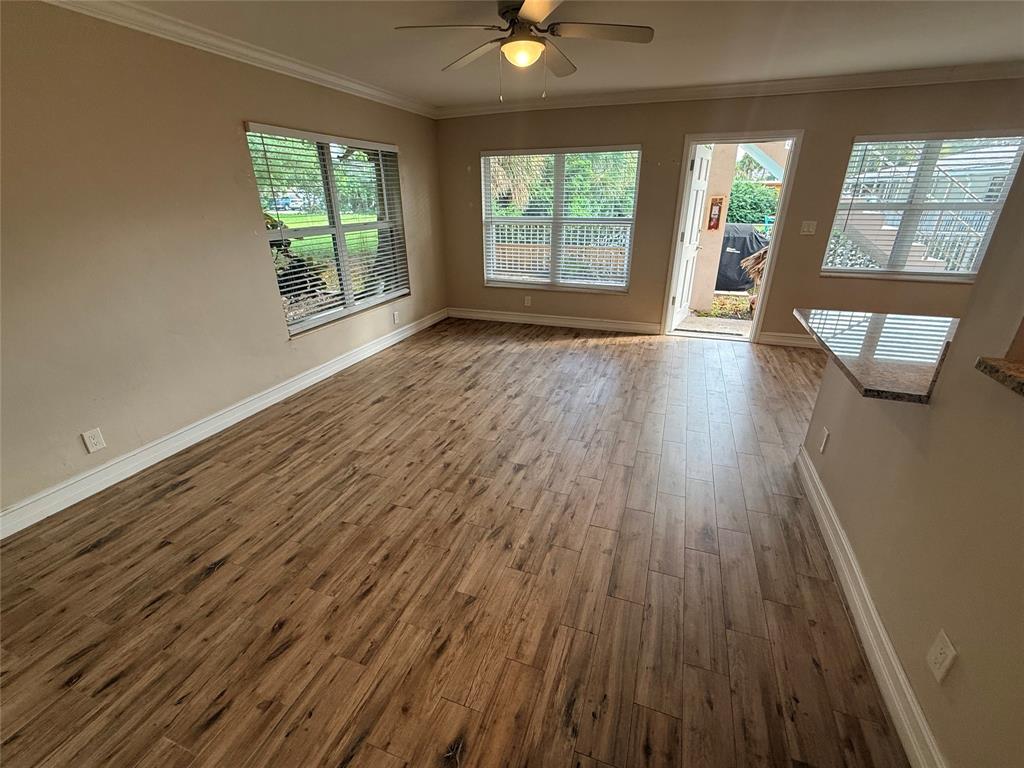 3217 Northeast 11th Street, Unit 7 Pompano Beach, FL 33062 - Photo 5 of 10 an empty room with wooden floor and windows