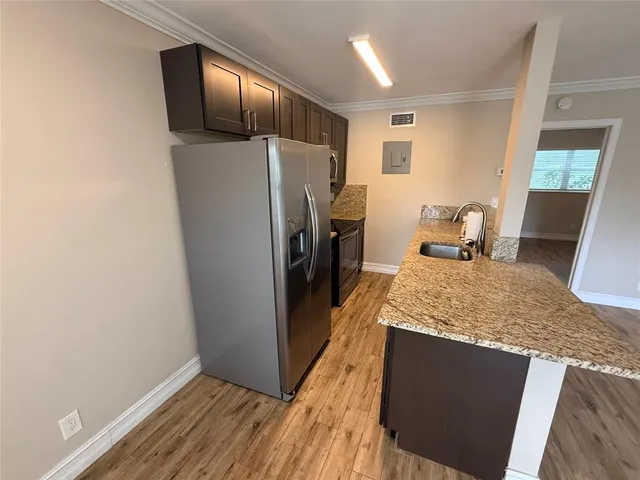 a kitchen with stainless steel appliances granite countertop a refrigerator and a sink