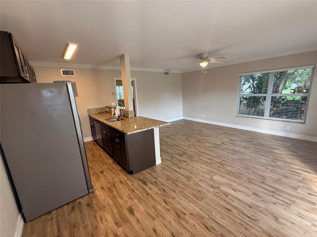 3217 Northeast 11th Street, Unit 7 Pompano Beach, FL 33062 - Photo 8 of 10 an empty room with wooden floor and windows