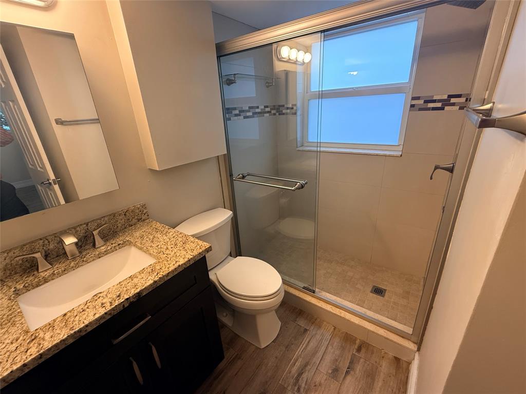 3217 Northeast 11th Street, Unit 7 Pompano Beach, FL 33062 - Photo 10 of 10 a bathroom with a granite countertop sink toilet and shower