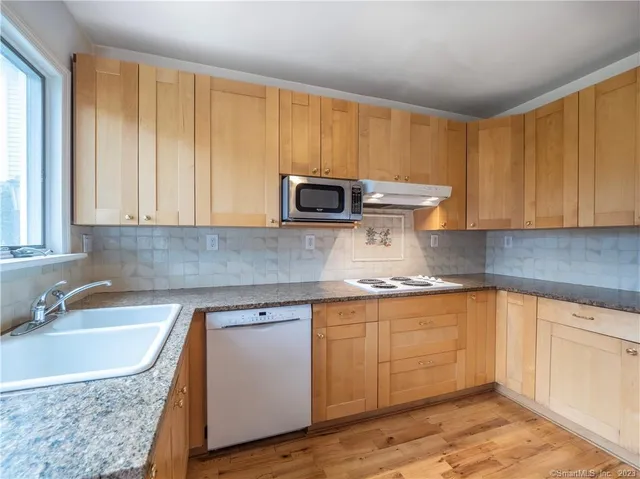 a kitchen with stainless steel appliances granite countertop wooden cabinets a sink and dishwasher