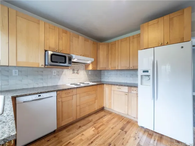 a kitchen with stainless steel appliances granite countertop a refrigerator sink and microwave