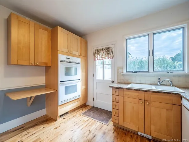 a kitchen with granite countertop cabinets stainless steel appliances a sink and a window