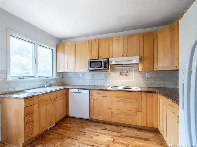 a kitchen with stainless steel appliances granite countertop a sink stove and cabinets