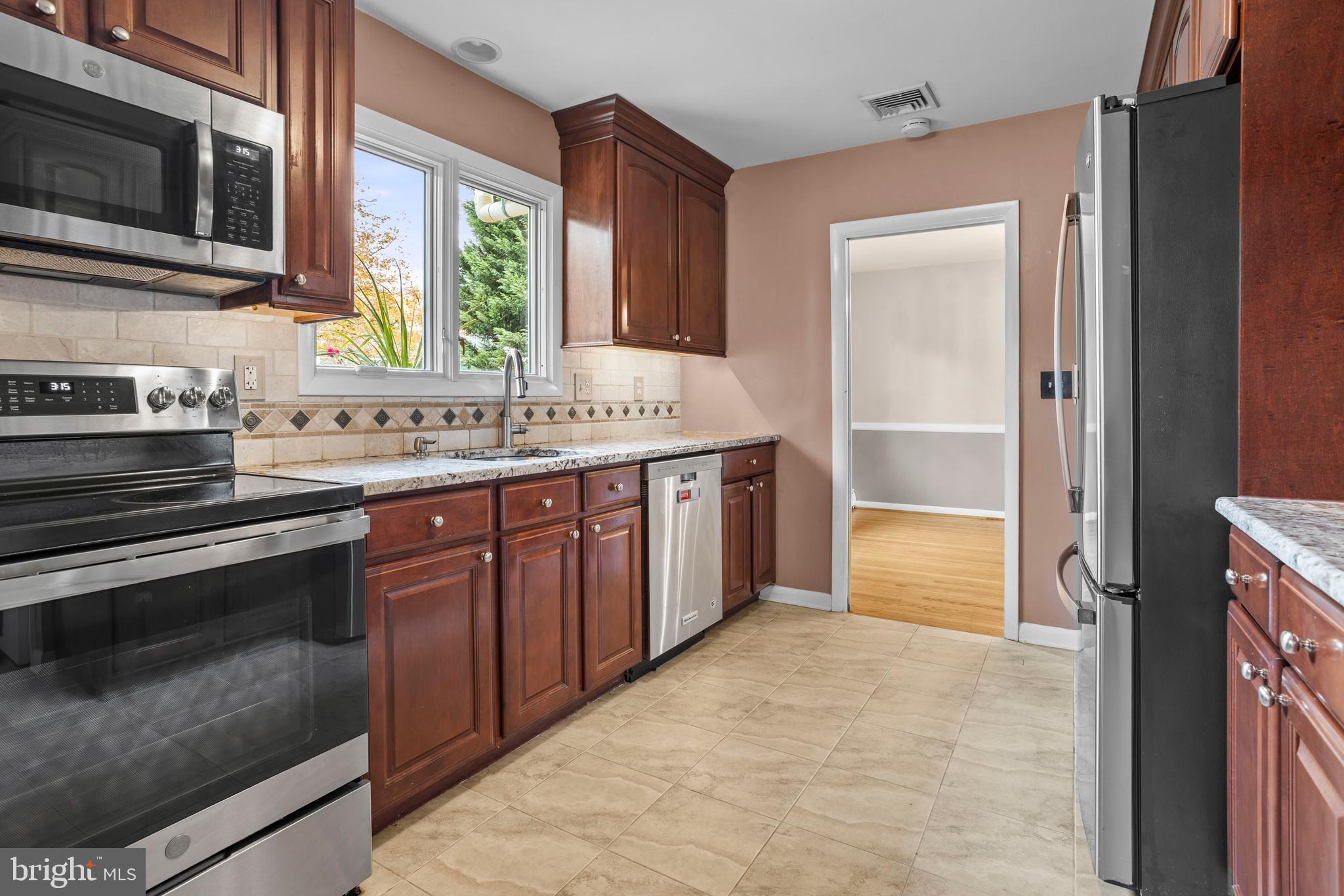 504 Minshall Road Springfield, PA 19064 - Photo 11 of 39 a kitchen with stainless steel appliances granite countertop a stove a sink and a microwave
