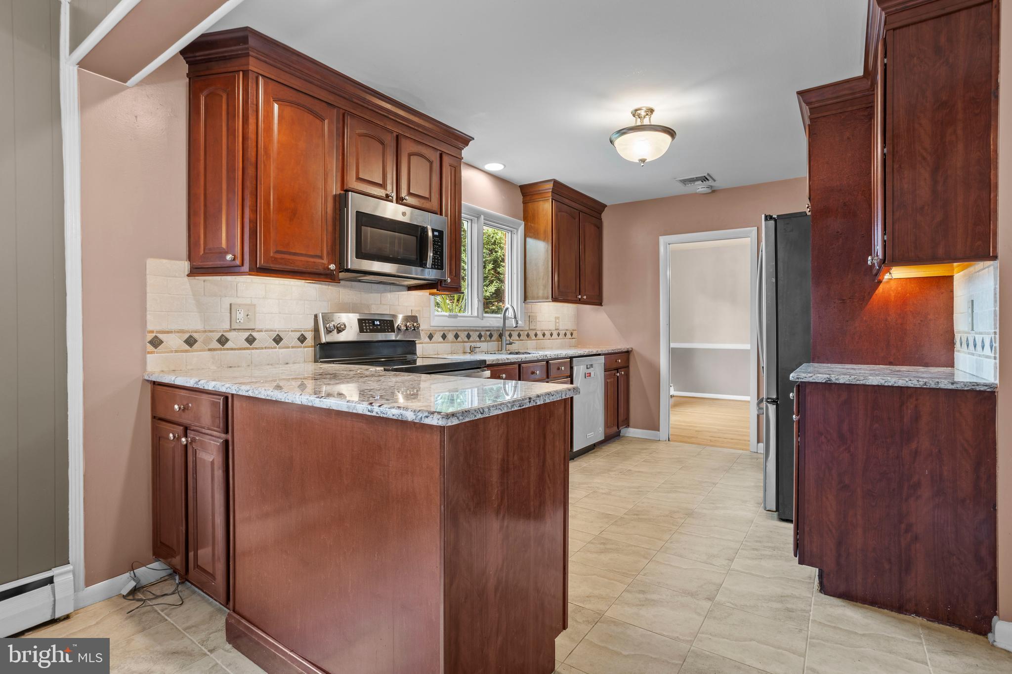 504 Minshall Road Springfield, PA 19064 - Photo 13 of 39 a kitchen with stainless steel appliances granite countertop a sink stove and refrigerator