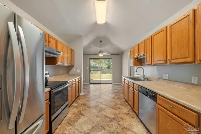 a kitchen with stainless steel appliances granite countertop a sink stove and refrigerator