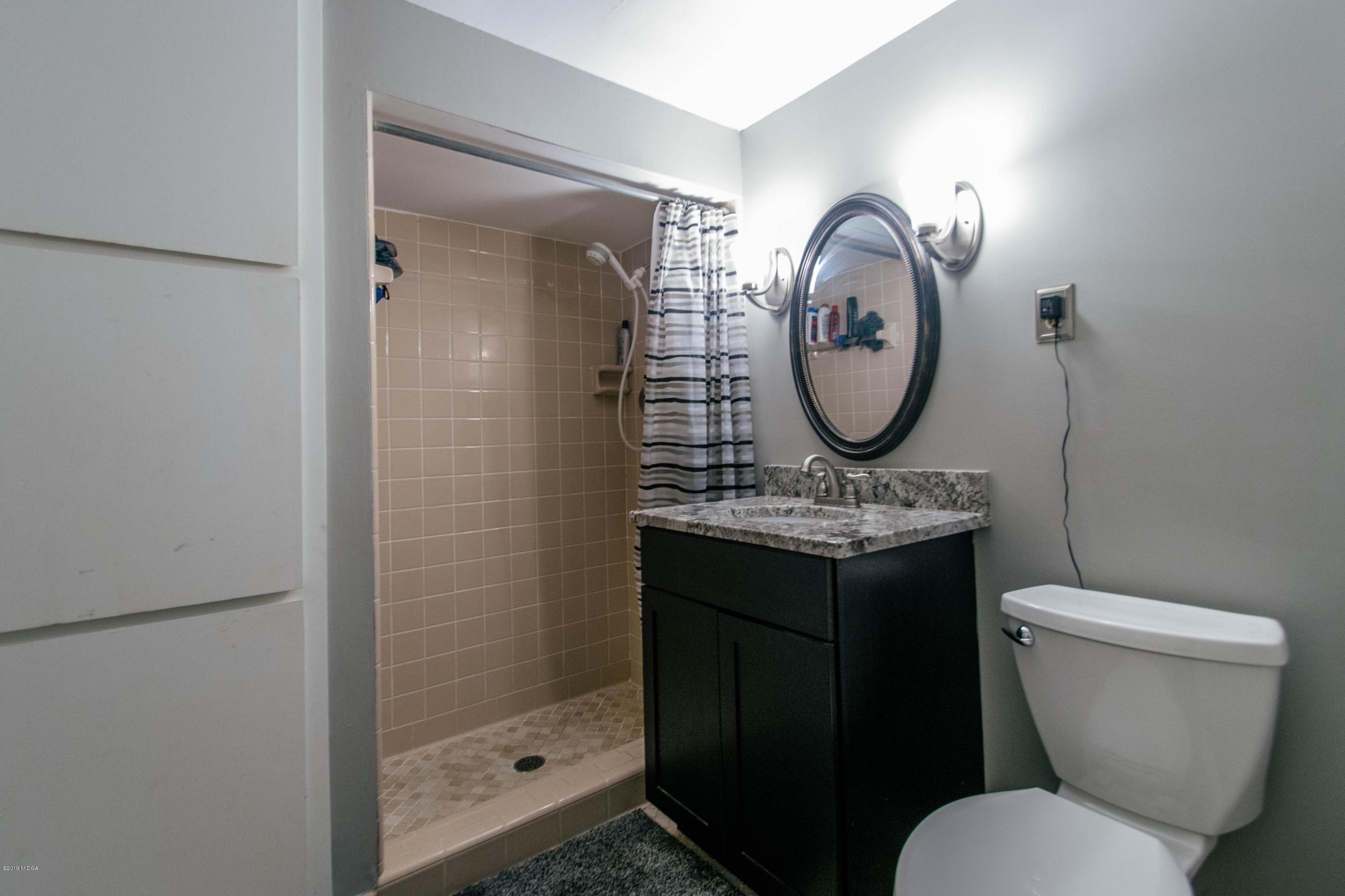 1403 Cambridge Road Perry, GA 31069 - Photo 18 of 38 a bathroom with a toilet a sink and a shower