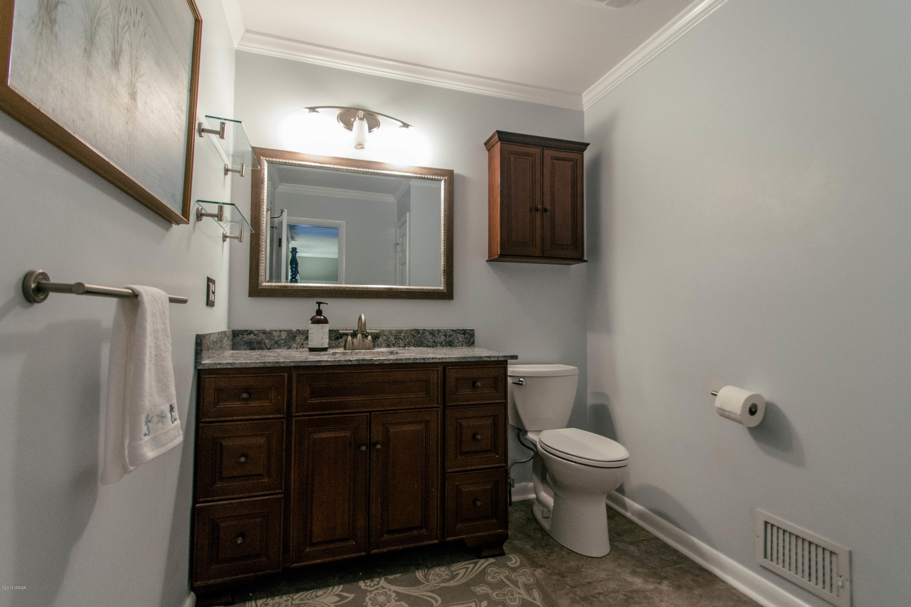 1403 Cambridge Road Perry, GA 31069 - Photo 30 of 38 a bathroom with a toilet a sink and mirror
