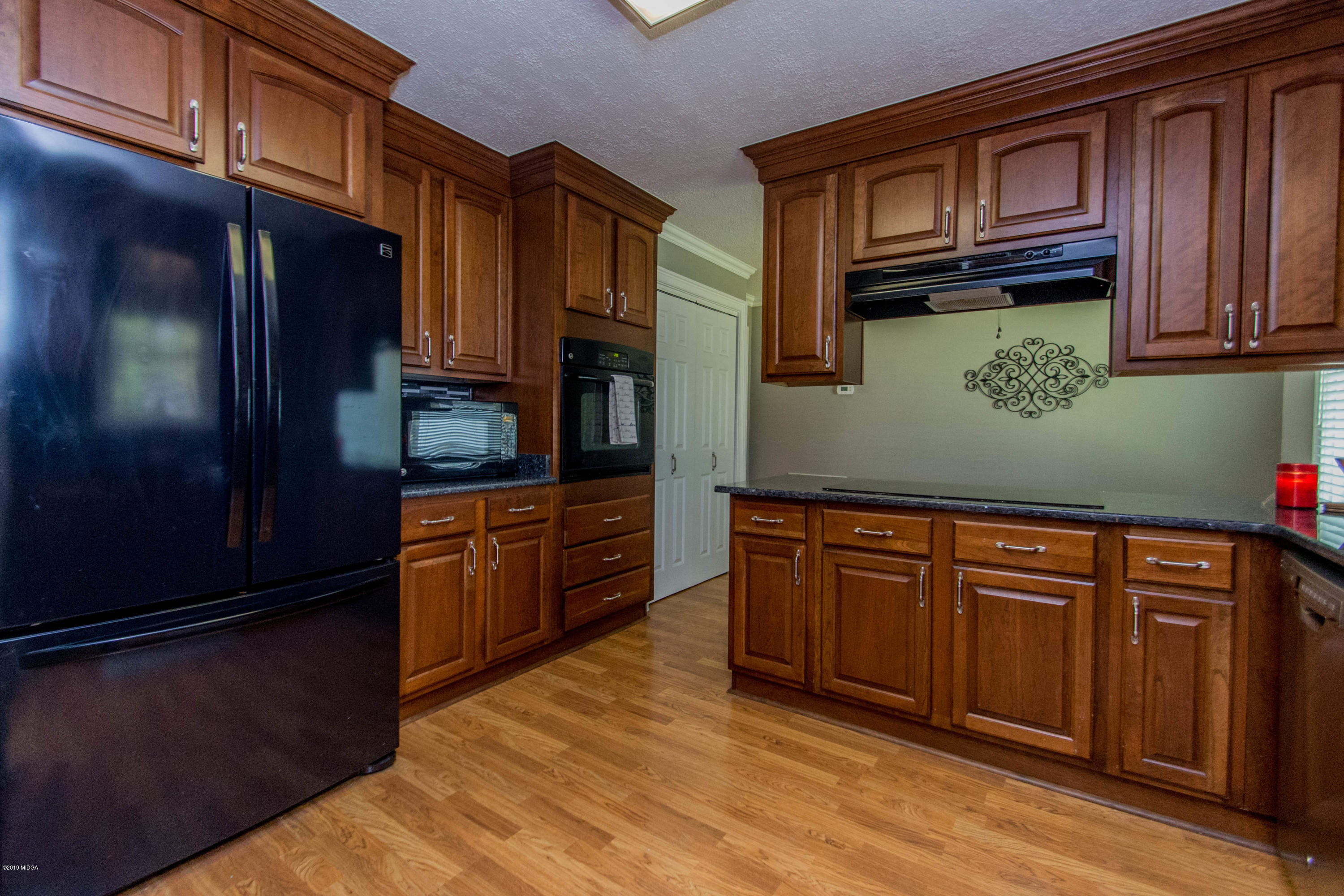 1403 Cambridge Road Perry, GA 31069 - Photo 6 of 38 a kitchen with granite countertop wooden cabinets and stainless steel appliances