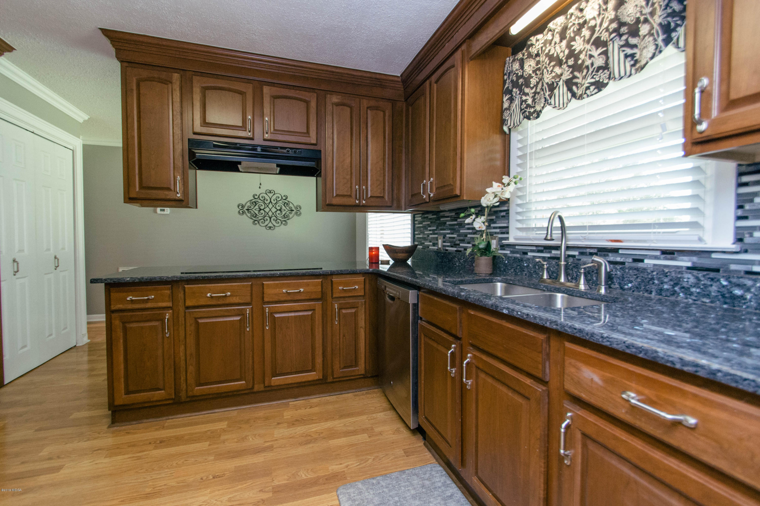 1403 Cambridge Road Perry, GA 31069 - Photo 7 of 38 a kitchen with granite countertop cabinets stainless steel appliances a sink and wooden floor
