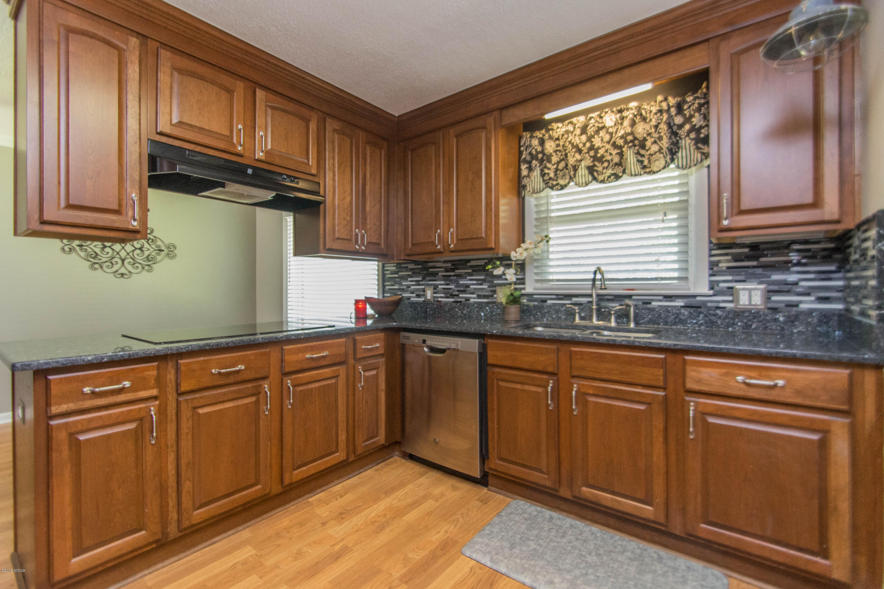1403 Cambridge Road Perry, GA 31069 - Photo 8 of 38 a kitchen with granite countertop cabinets stainless steel appliances a sink and a window