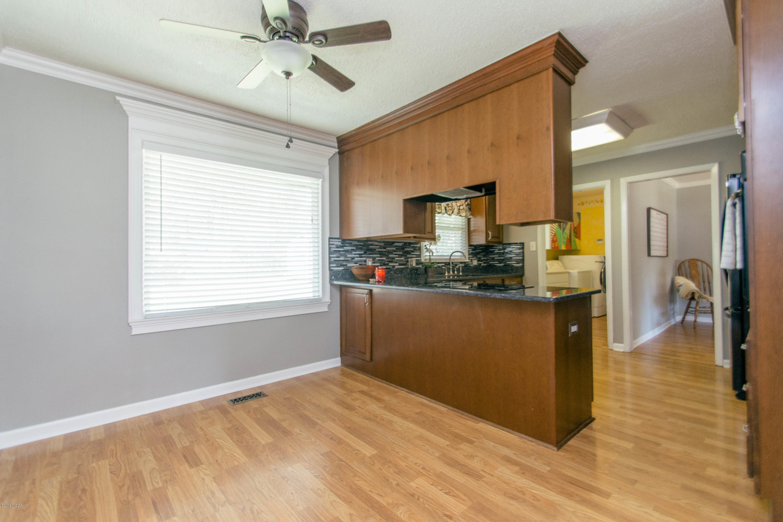 1403 Cambridge Road Perry, GA 31069 - Photo 10 of 38 a kitchen with kitchen island a counter top space appliances and a ceiling fan