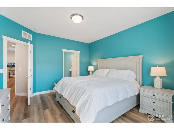 a bedroom with a bed and a flat tv screen on dresser