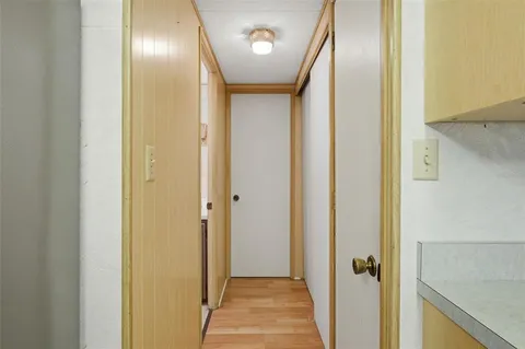 a view of a hallway with wooden floor