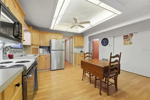 a kitchen with refrigerator a table and chairs in it