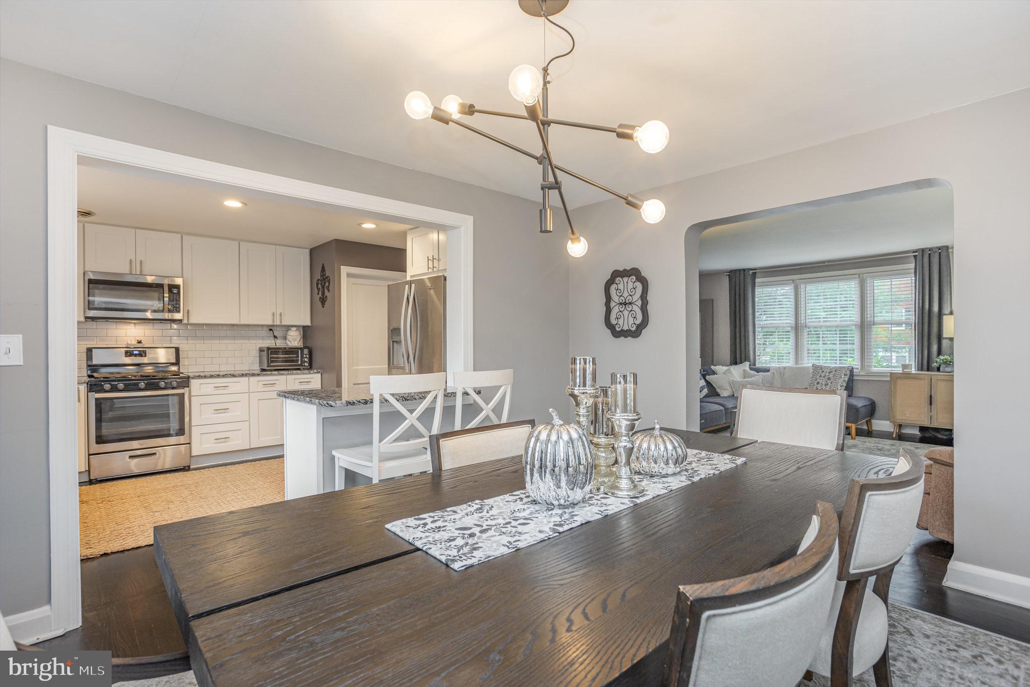1500 Doxbury Road Baltimore, MD 21286 - Photo 14 of 36 a large kitchen with granite countertop a stove a sink a dining table and chairs with wooden floor