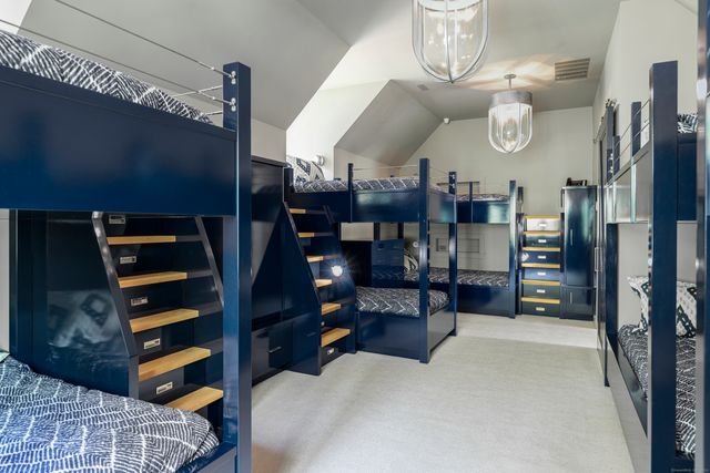 a front view of a house with a garden and trees