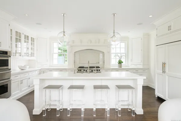 a kitchen with a stove a sink a dining table and chairs