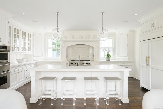 a kitchen with a stove a sink a dining table and chairs