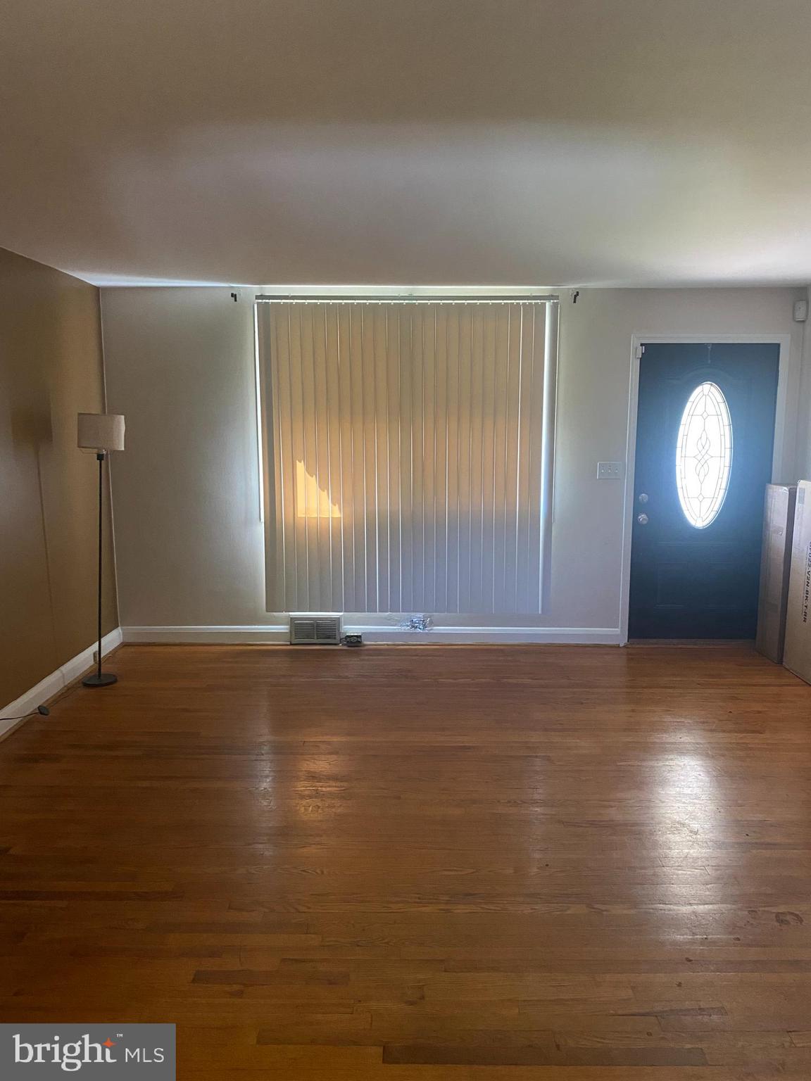 906 Masefield Road Baltimore, MD 21207 - Photo 4 of 22 an empty room with wooden floor and windows