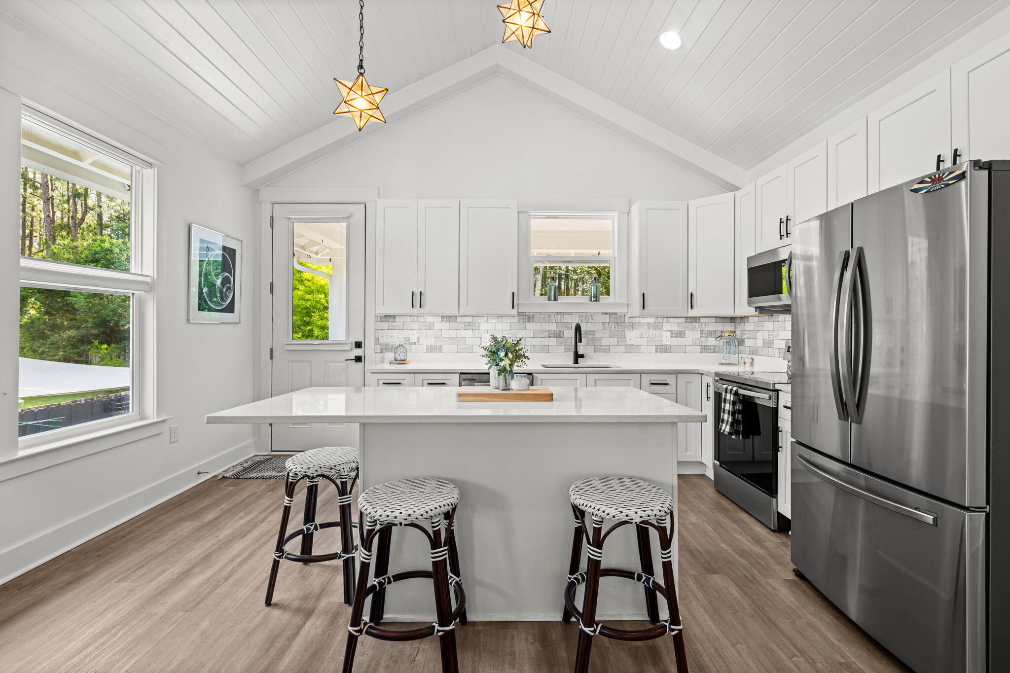 85 6th Street Santa Rosa Beach, FL 32459 - Photo 10 of 35 a kitchen with stainless steel appliances a sink a stove a refrigerator cabinets and dining table